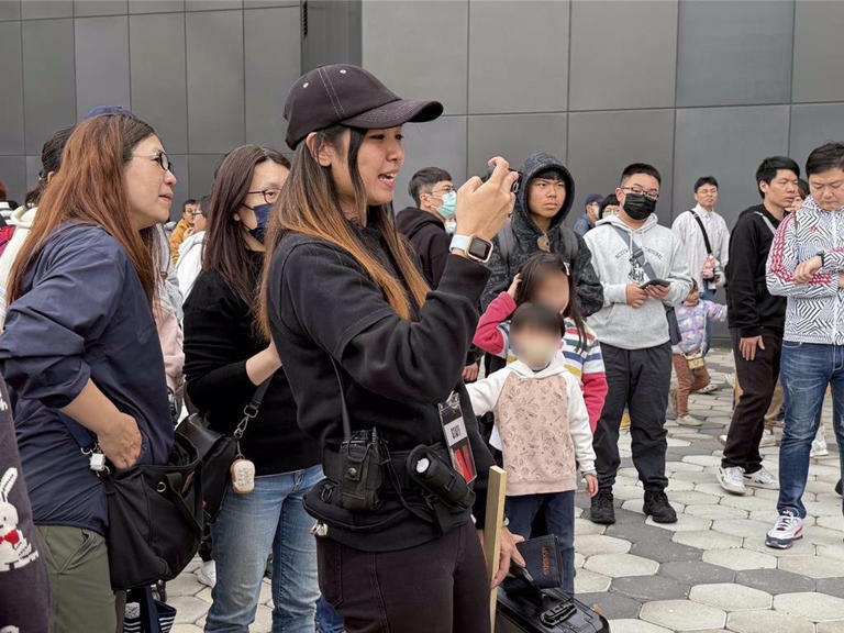 主辦單位工作人員，除了在現場辛苦靠著大喊維持秩序，還得協助幫民眾拍照。（紀爰攝）